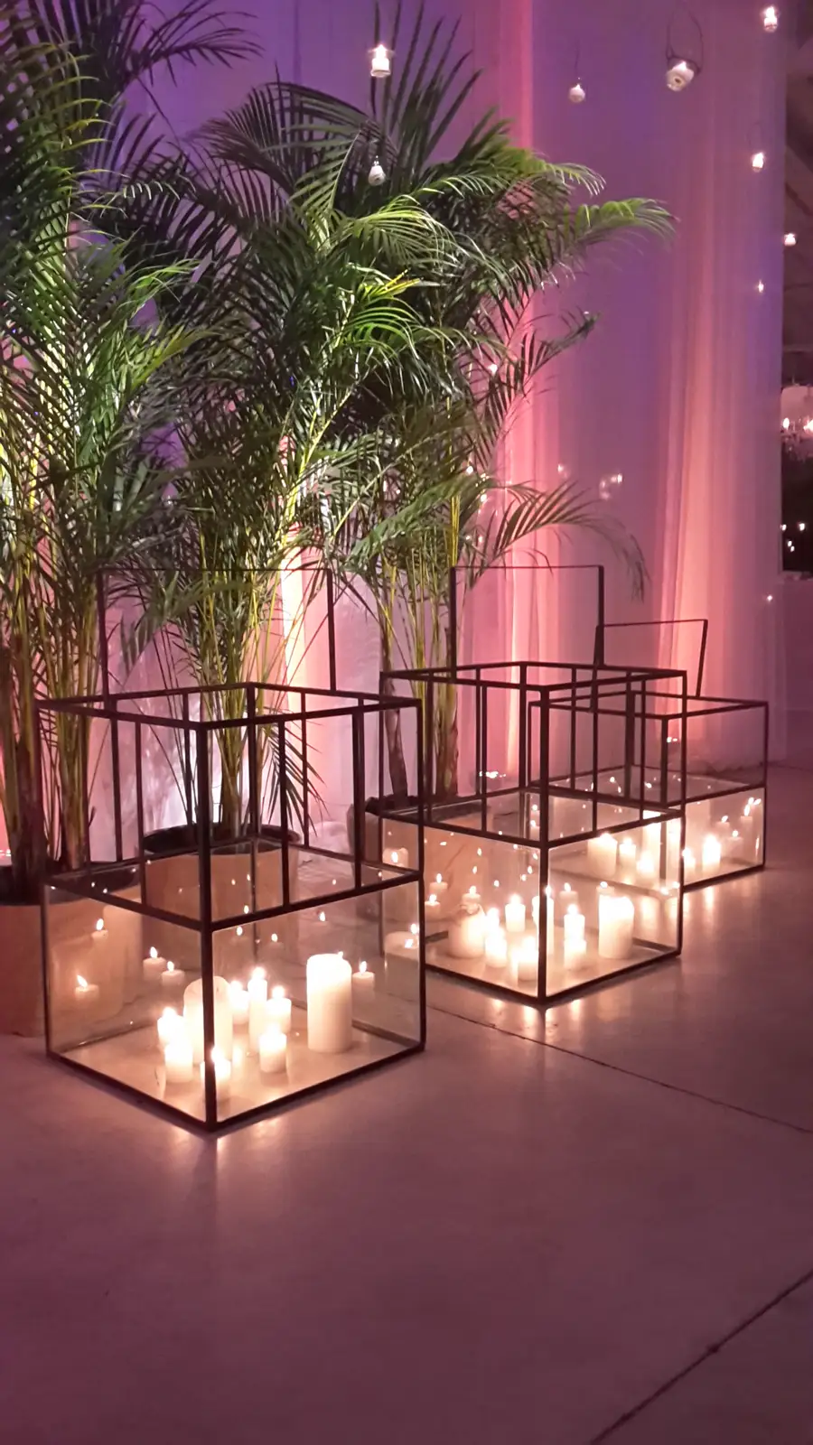 Cubos de hierro con velas y palmeras